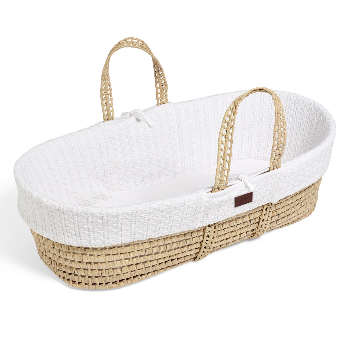 A cosy white Moses basket with a natural handle