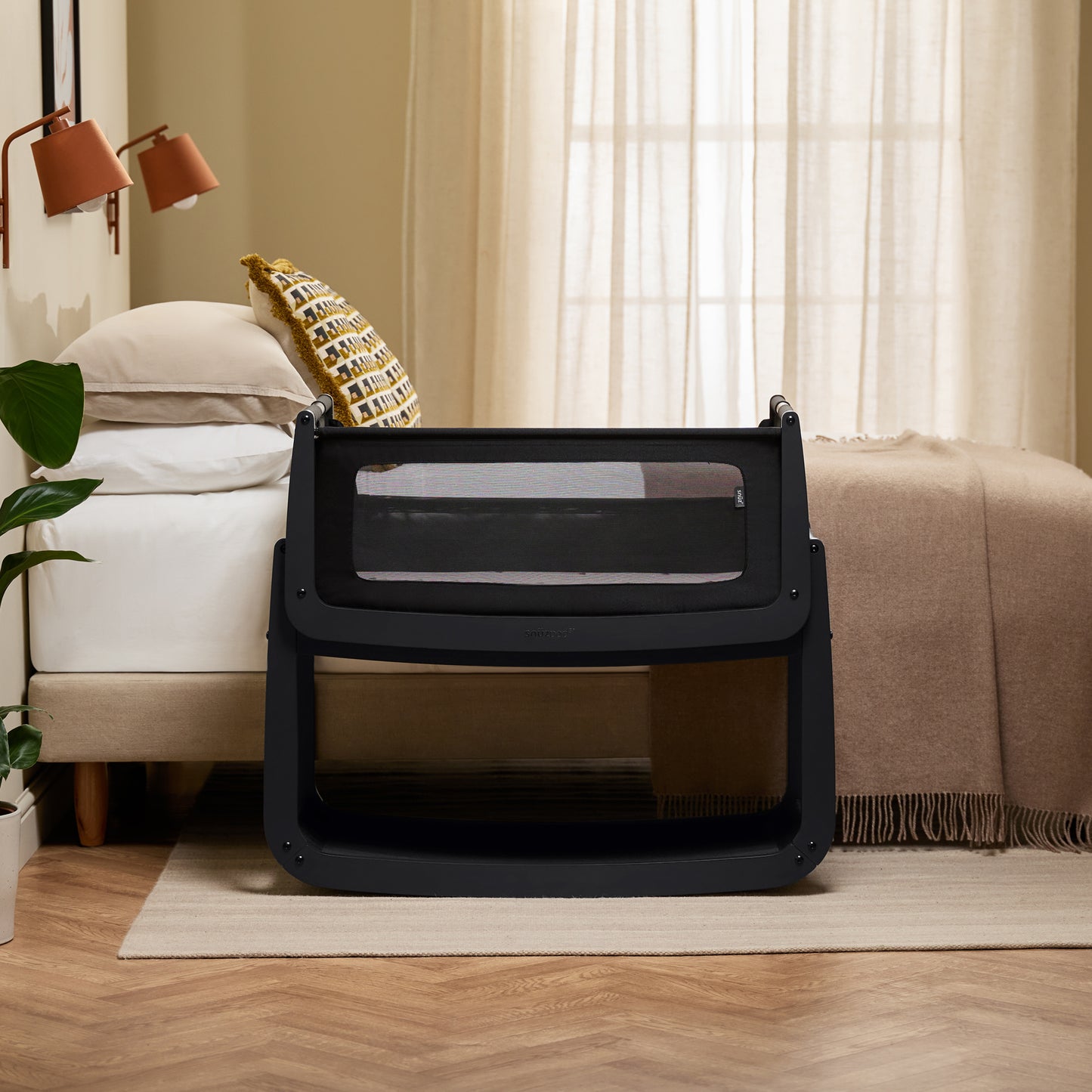 A Graphite Snuzpod5 bedside crib designed for infants, showcasing a modern and safe sleeping environment.