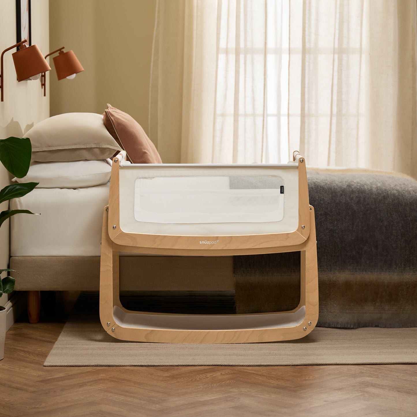 A Natural Snuzpod5 bedside crib designed for infants, showcasing a modern and safe sleeping environment.