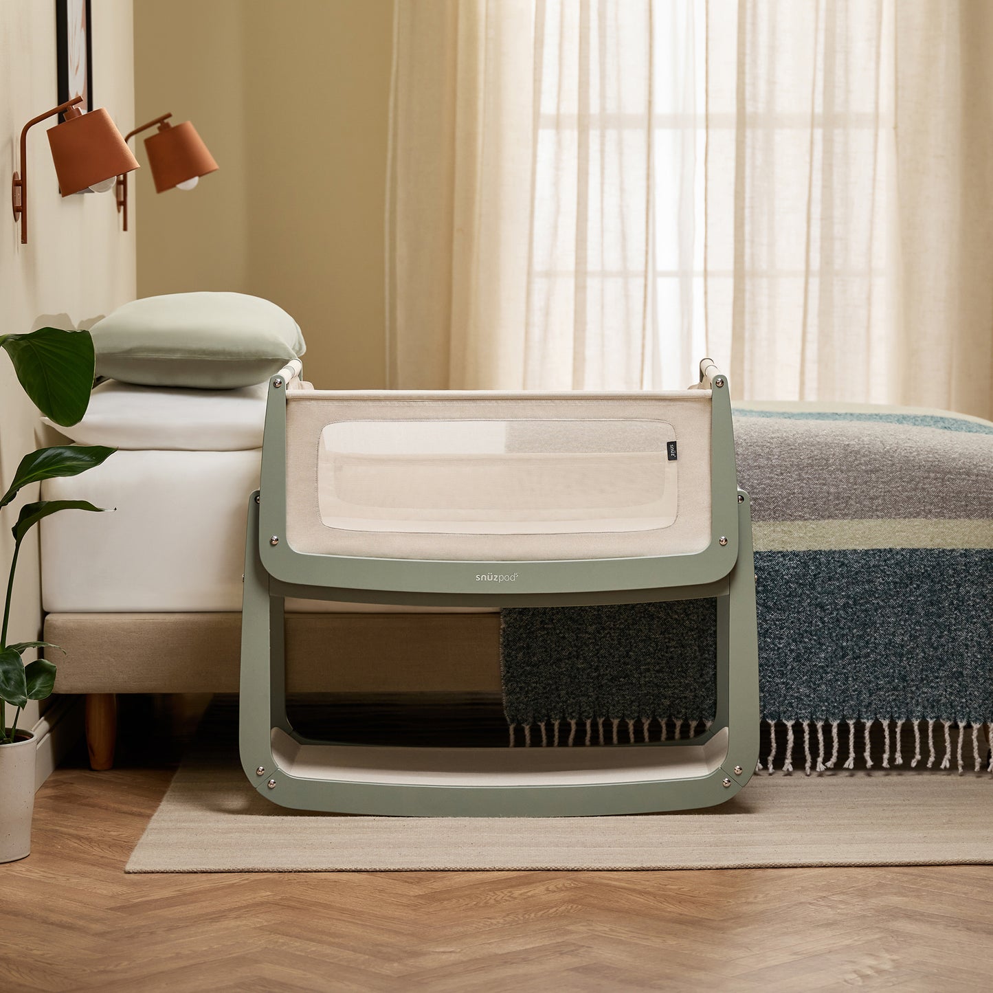 A Sage Snuzpod5 bedside crib designed for infants, showcasing a modern and safe sleeping environment.