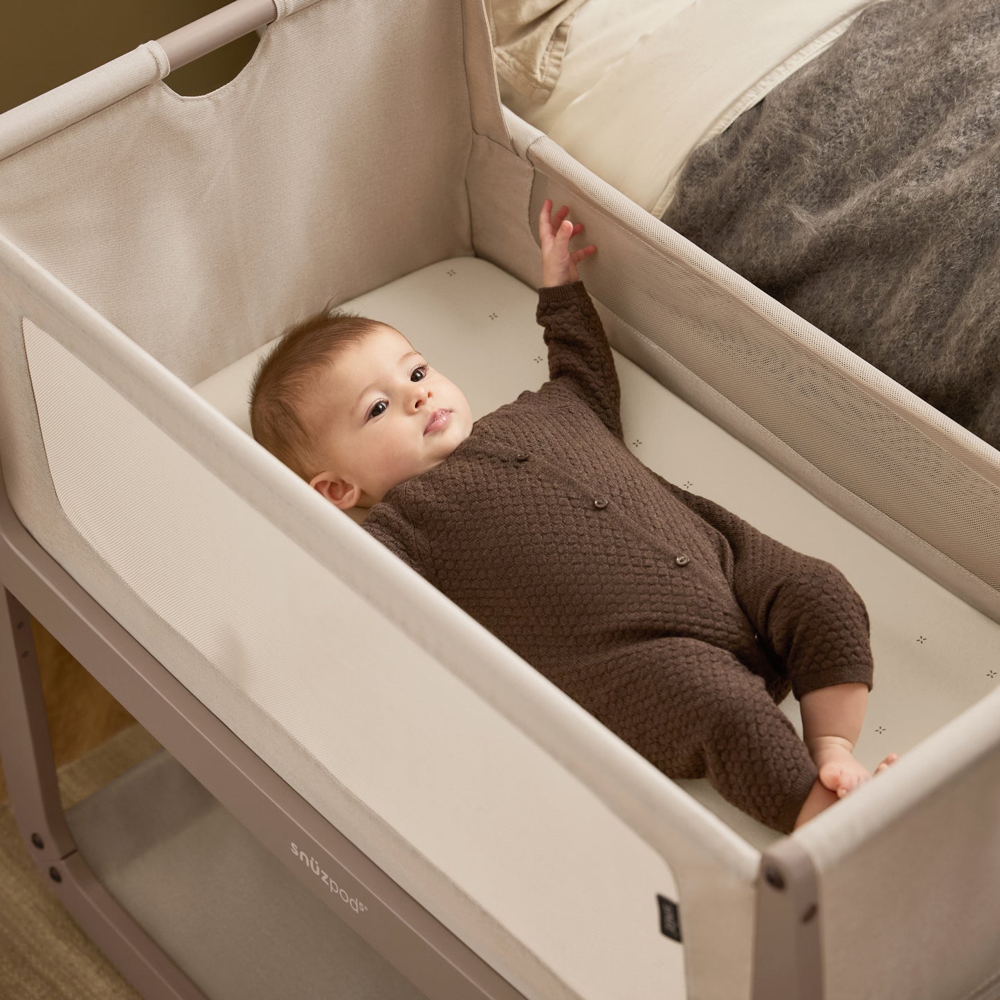 A Mocha Snuzpod5 bedside crib designed for infants, showcasing a modern and safe sleeping environment.