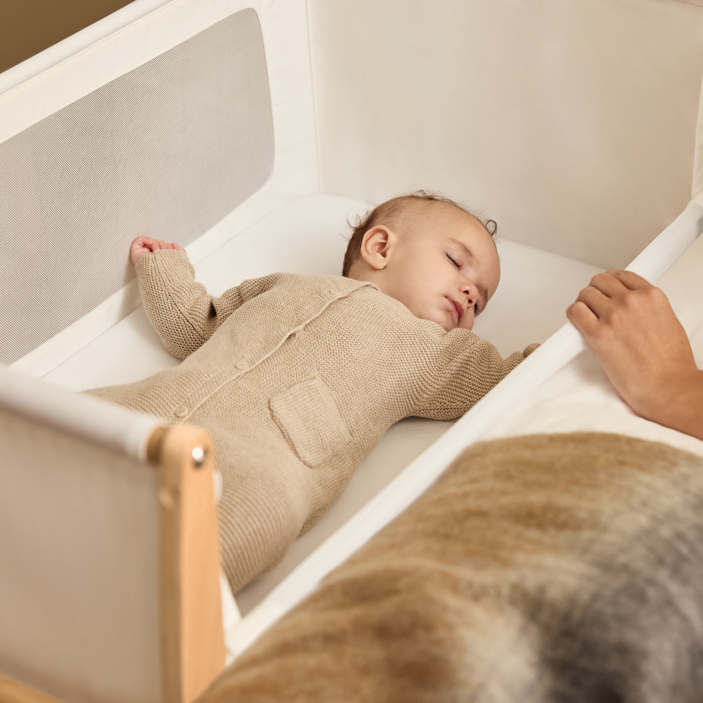 A Natural Snuzpod5 bedside crib designed for infants, showcasing a modern and safe sleeping environment.