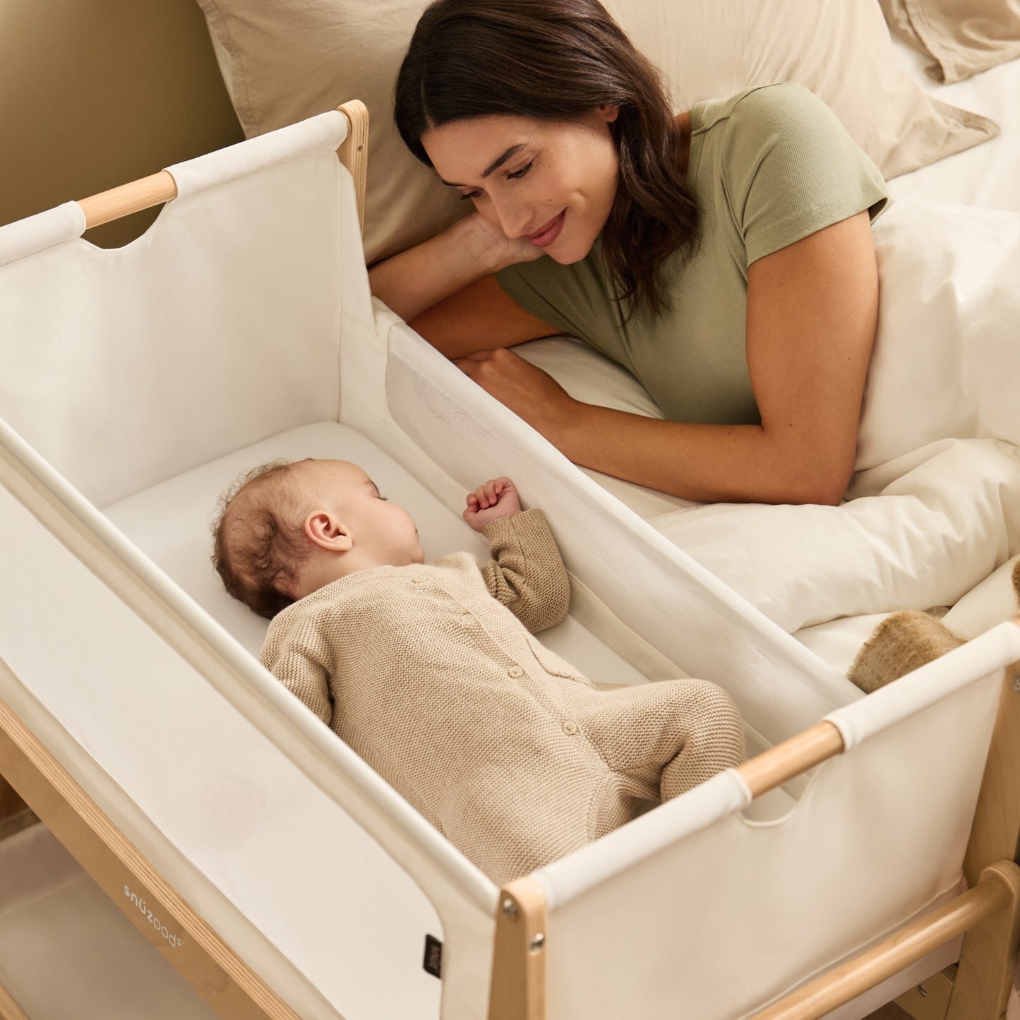 A Natural Snuzpod5 bedside crib designed for infants, showcasing a modern and safe sleeping environment.