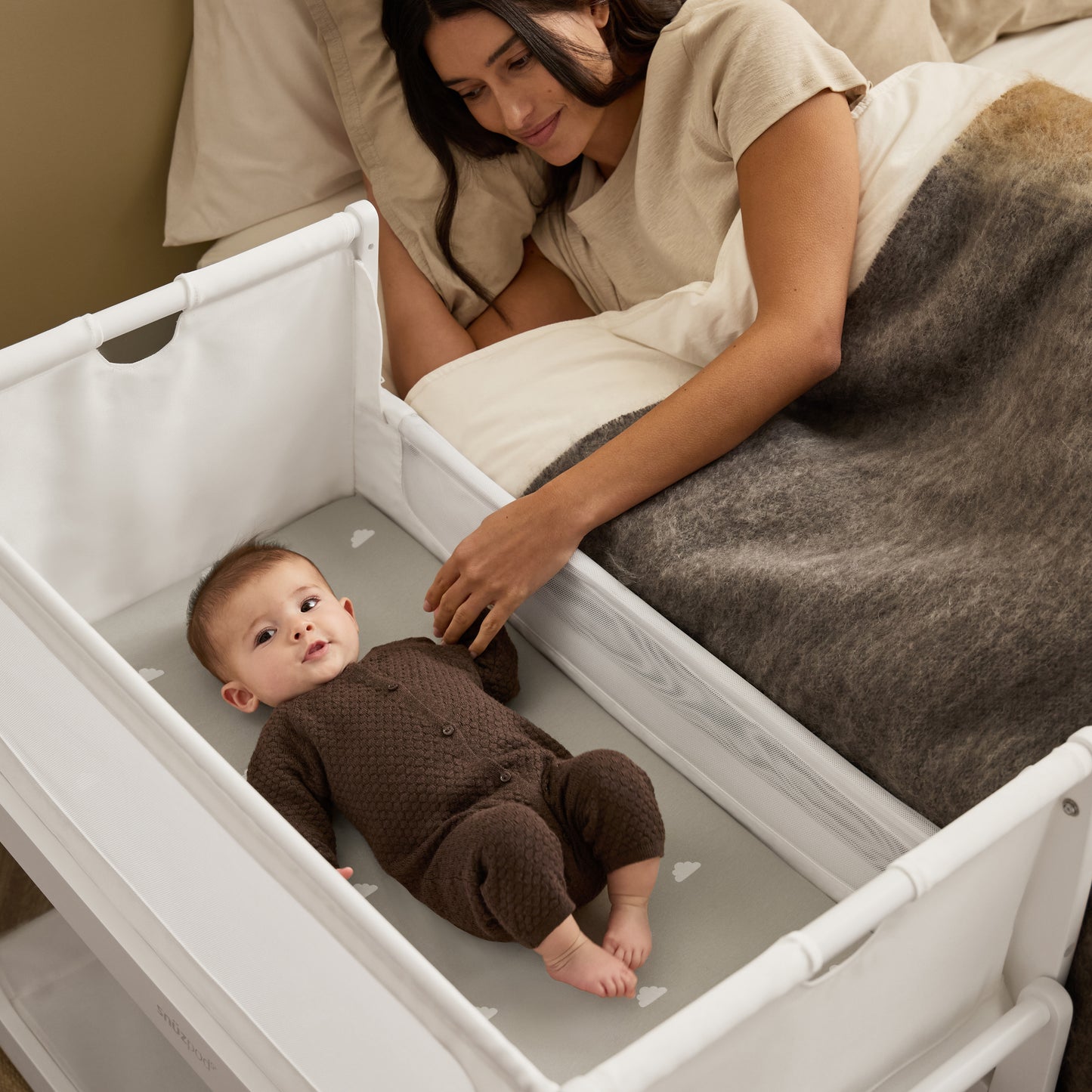A White Snuzpod5 bedside crib designed for infants, showcasing a modern and safe sleeping environment.