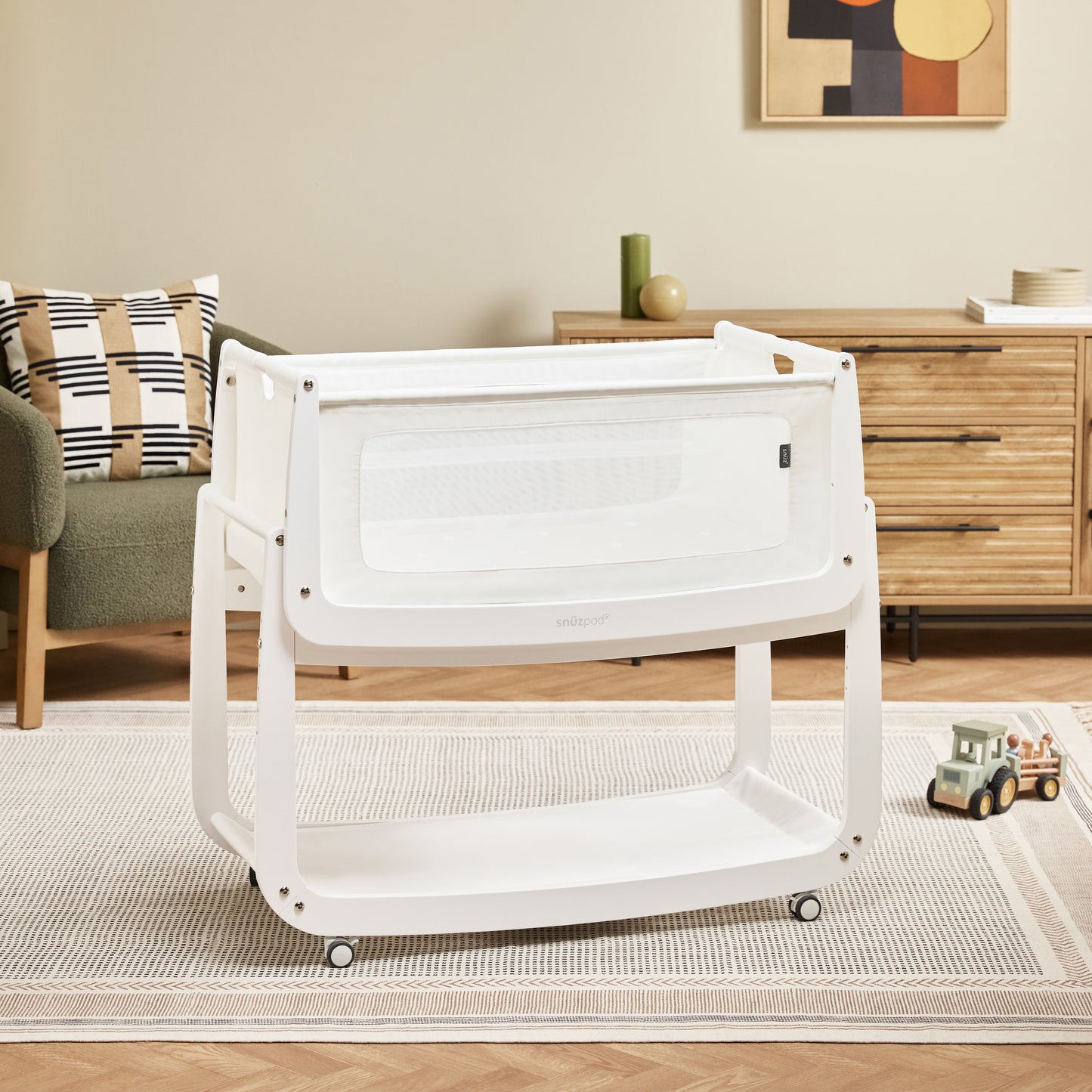 A White Snuzpod5 bedside crib designed for infants, showcasing a modern and safe sleeping environment.