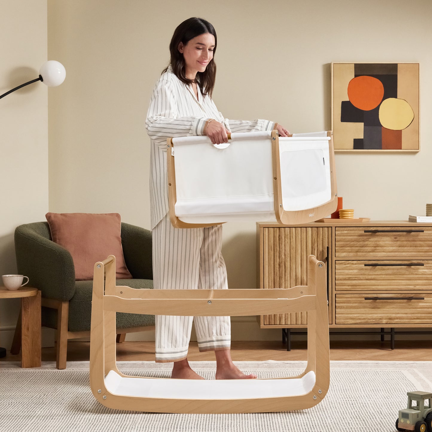 A Natural Snuzpod5 bedside crib designed for infants, showcasing a modern and safe sleeping environment.