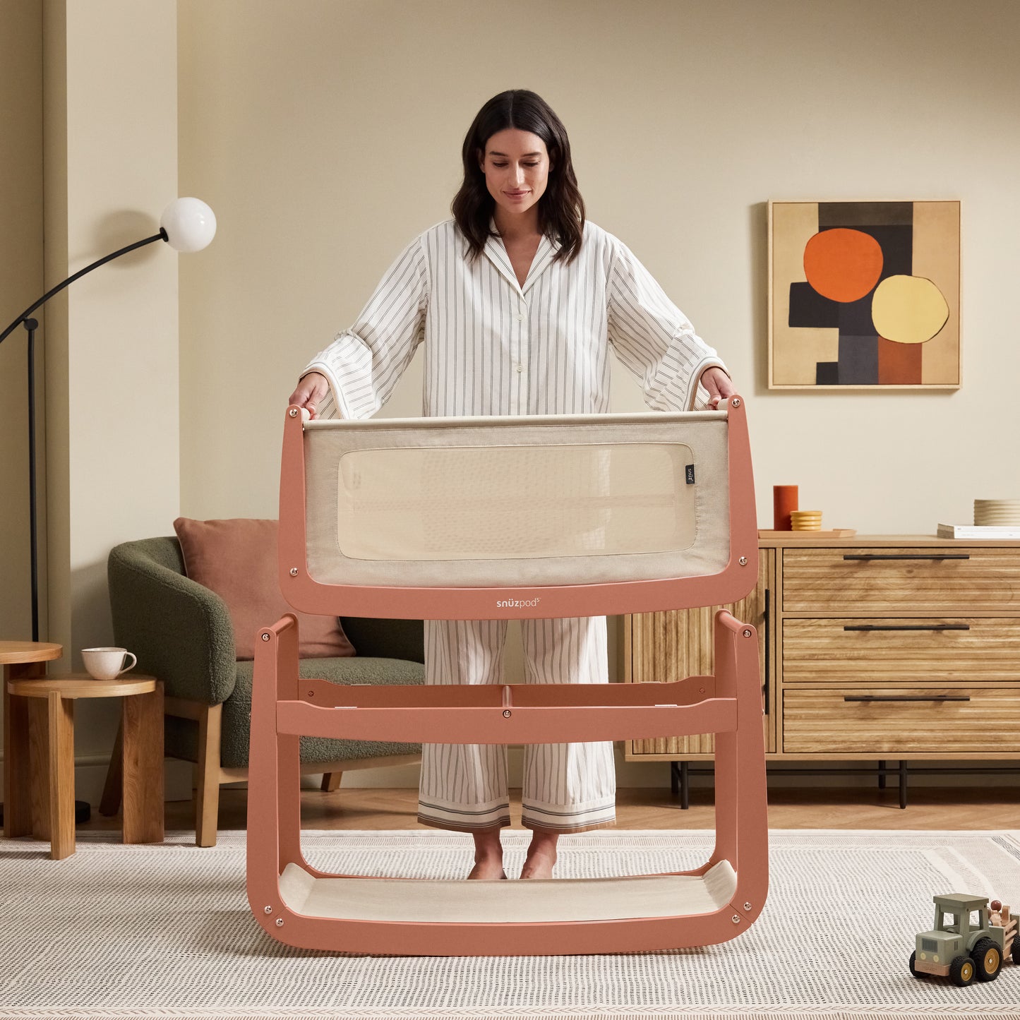 A Terracotta Snuzpod5 bedside crib designed for infants, showcasing a modern and safe sleeping environment.