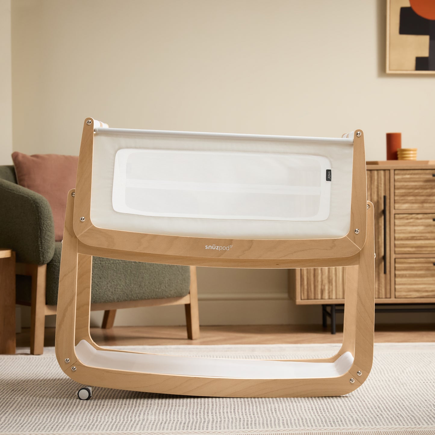 A Natural Snuzpod5 bedside crib designed for infants, showcasing a modern and safe sleeping environment.