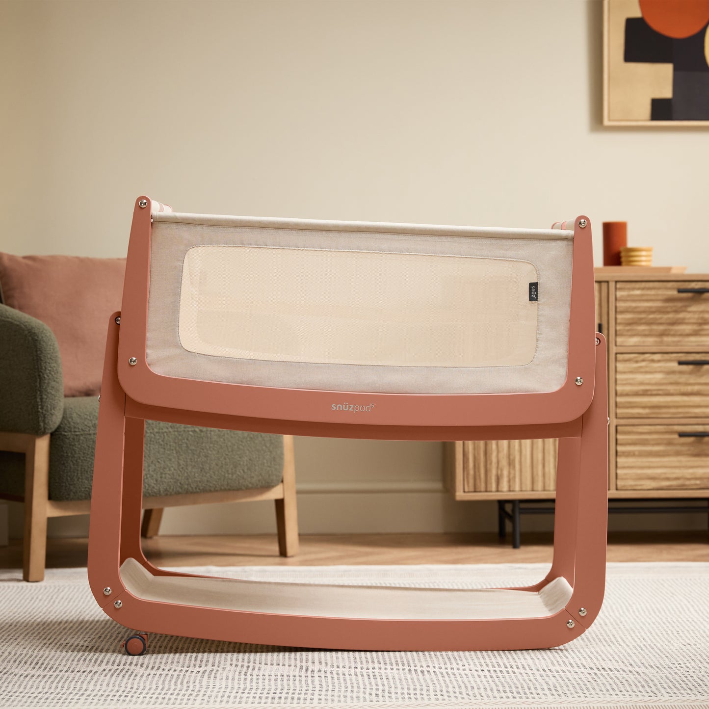 A Terracotta Snuzpod5 bedside crib designed for infants, showcasing a modern and safe sleeping environment.
