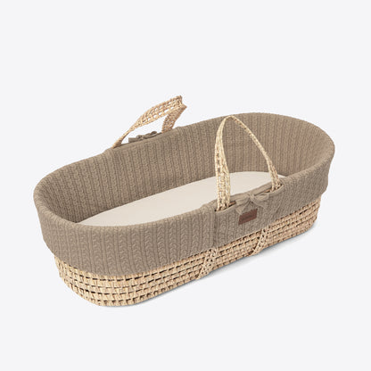 A cosy truffle Moses basket with a natural handle 