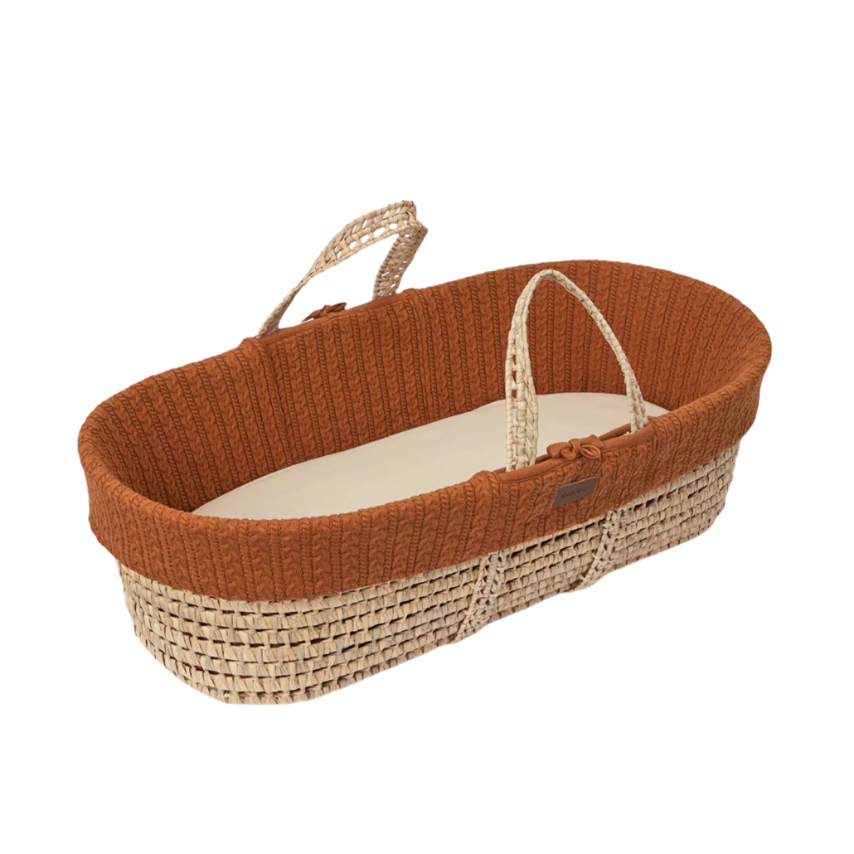 A cosy terracotta Moses basket with a natural handle 