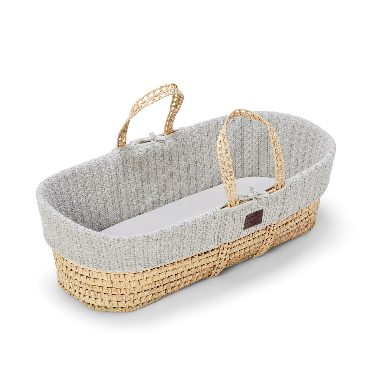 A cosy dove Moses basket with a natural handle 