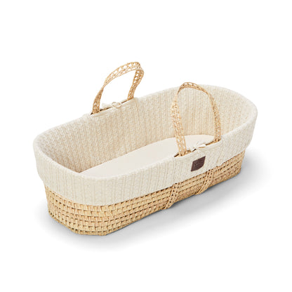 A cosy linen Moses basket with a natural handle