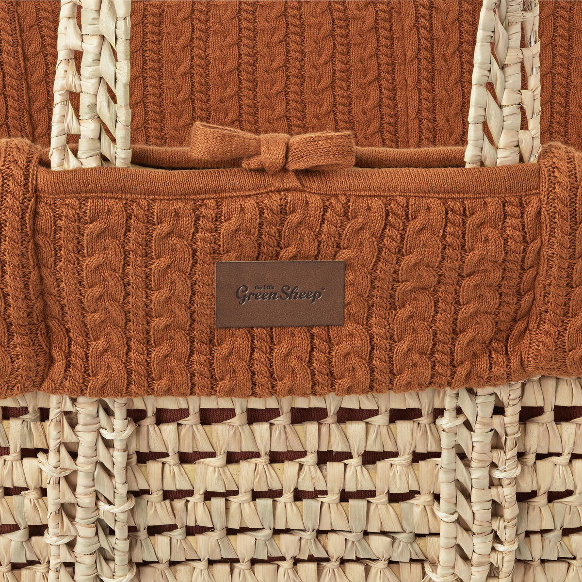 Terracotta moses basket with a close up view of stitching