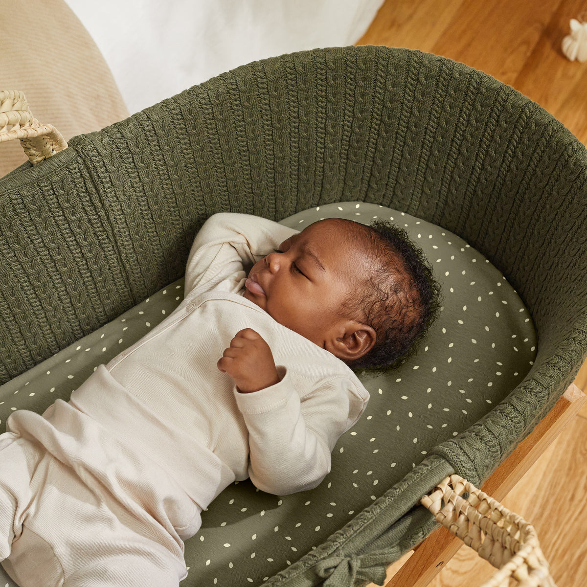 Juniper Moses basket with baby sleeping comfortably on top.