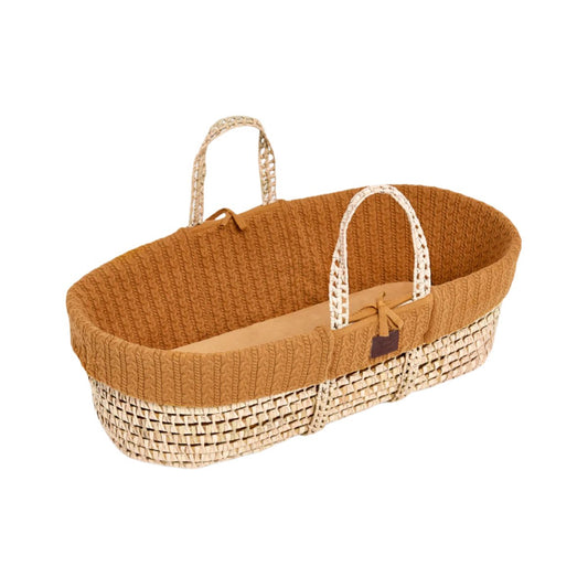 A cosy Honey Moses basket with a natural handle