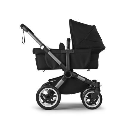 Midnight Black Bugaboo Donkey 5 stroller with seat and carrycot fabrics, designed for easy folding and adaptable for duo or twin configurations.