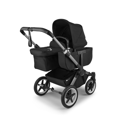 Midnight Black Bugaboo Donkey 5 stroller with seat and carrycot fabrics, designed for easy folding and adaptable for duo or twin configurations.