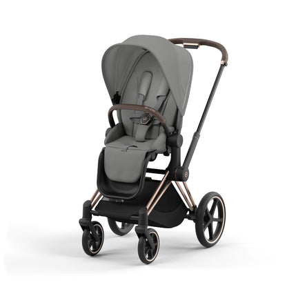 Cybex Priam rose gold chassis with dark brown handle and mirage grey seat pack.