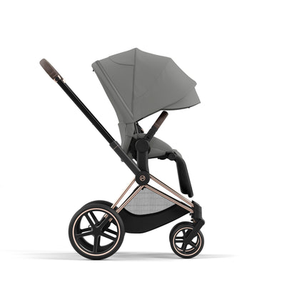 Cybex Priam rose gold chassis with dark brown handle and mirage grey seat pack.