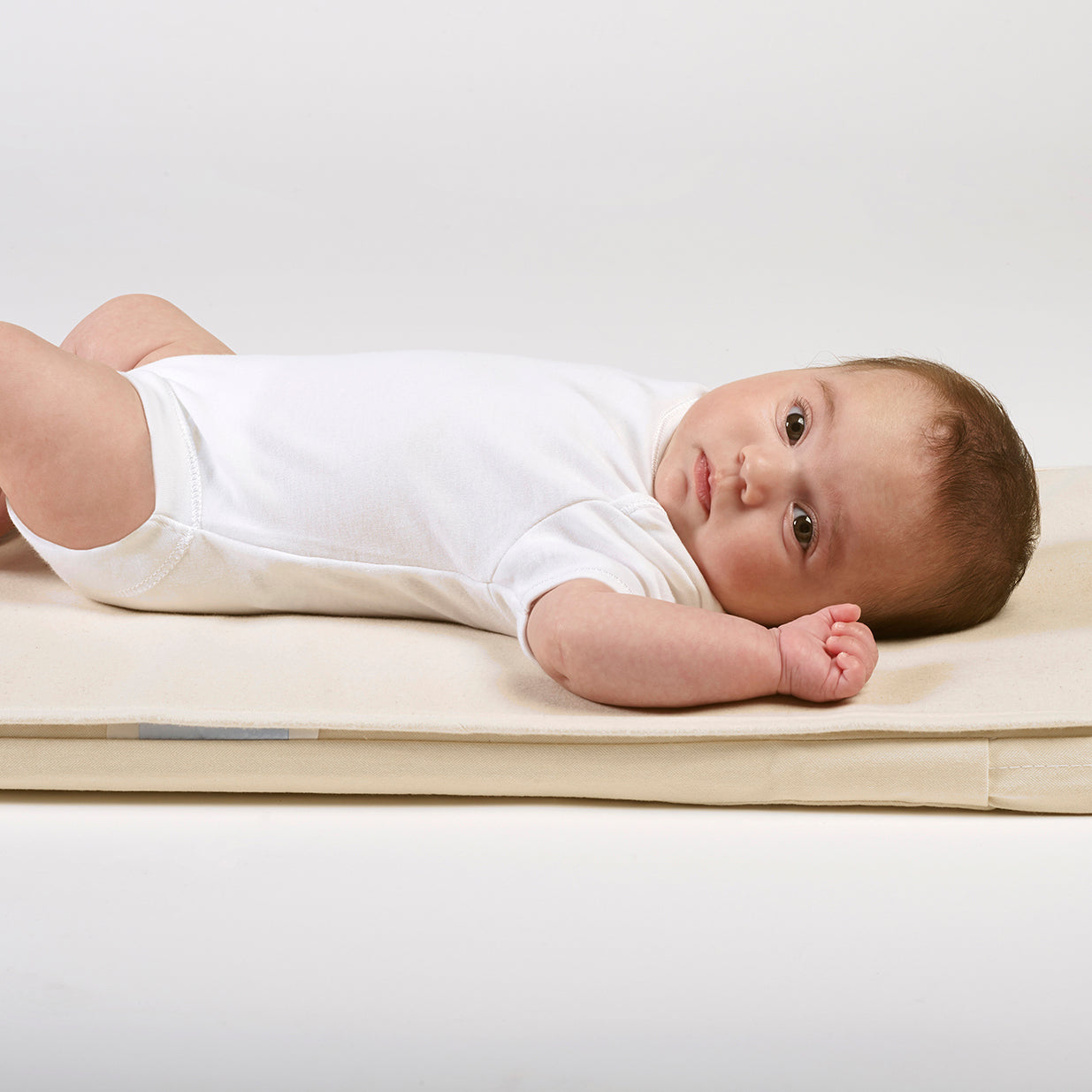 Baby lying down comfortably on mattress protector