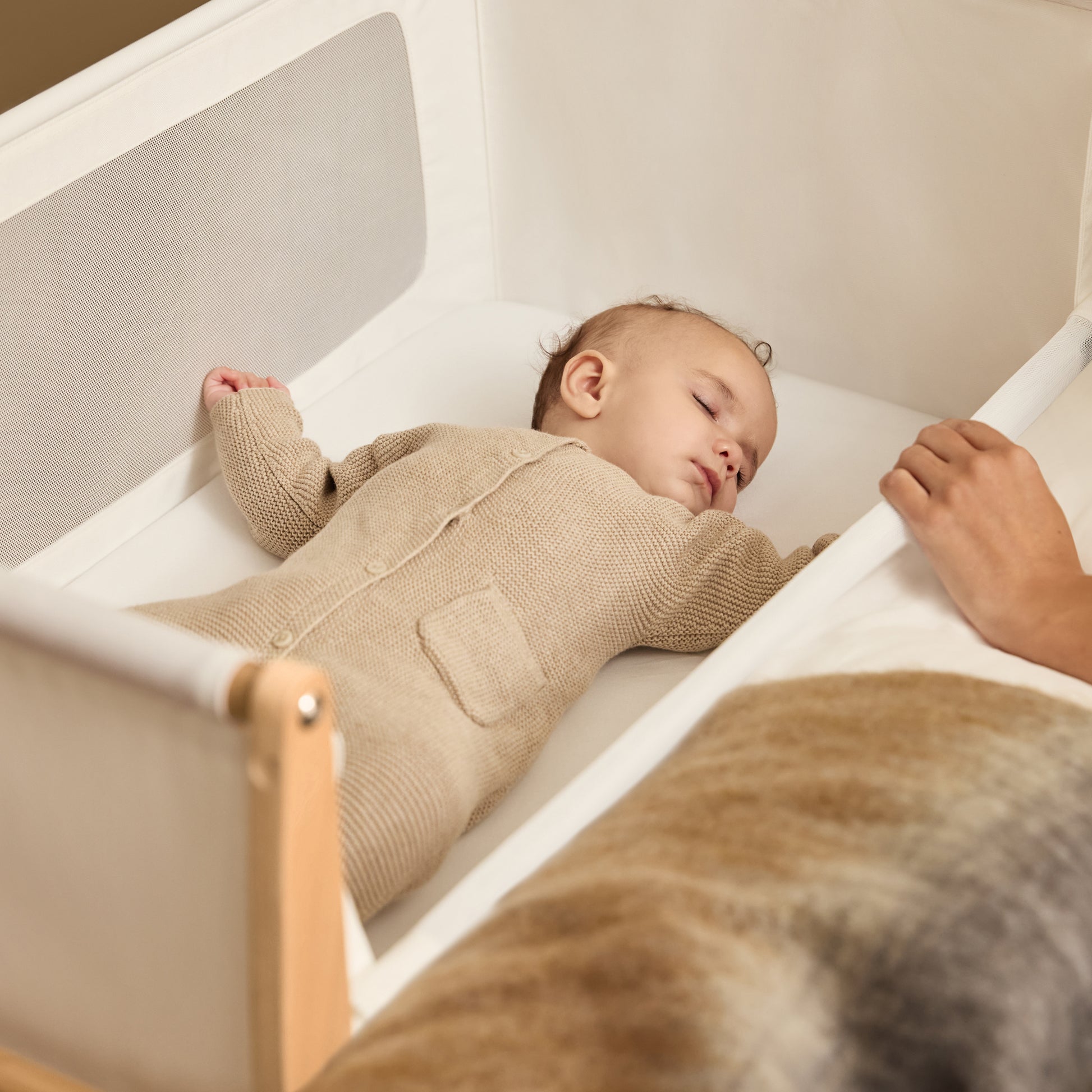 A Natural Snuzpod5 bedside crib designed for infants, showcasing a modern and safe sleeping environment.