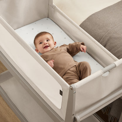 A Pebble Snuzpod5 bedside crib designed for infants, showcasing a modern and safe sleeping environment.
