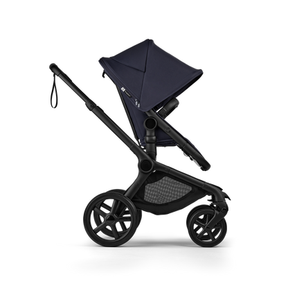 The deep indigo Bugaboo Fox5 pushchair, equipped with a seat and carrycot fabric, offers a compact fold for all-terrain use.