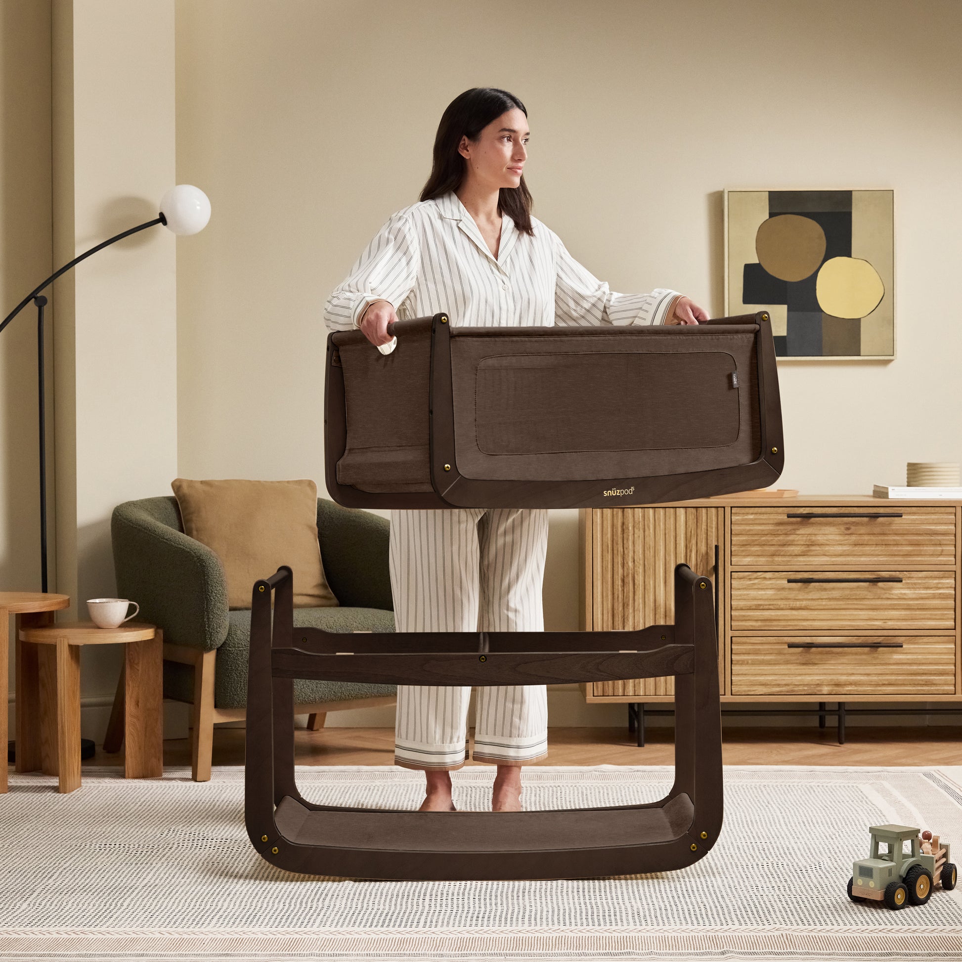 A choclate brown Snuzpod5 bedside crib designed for infants, showcasing a modern and safe sleeping environment.