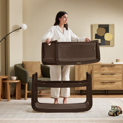 A choclate brown Snuzpod5 bedside crib designed for infants, showcasing a modern and safe sleeping environment.