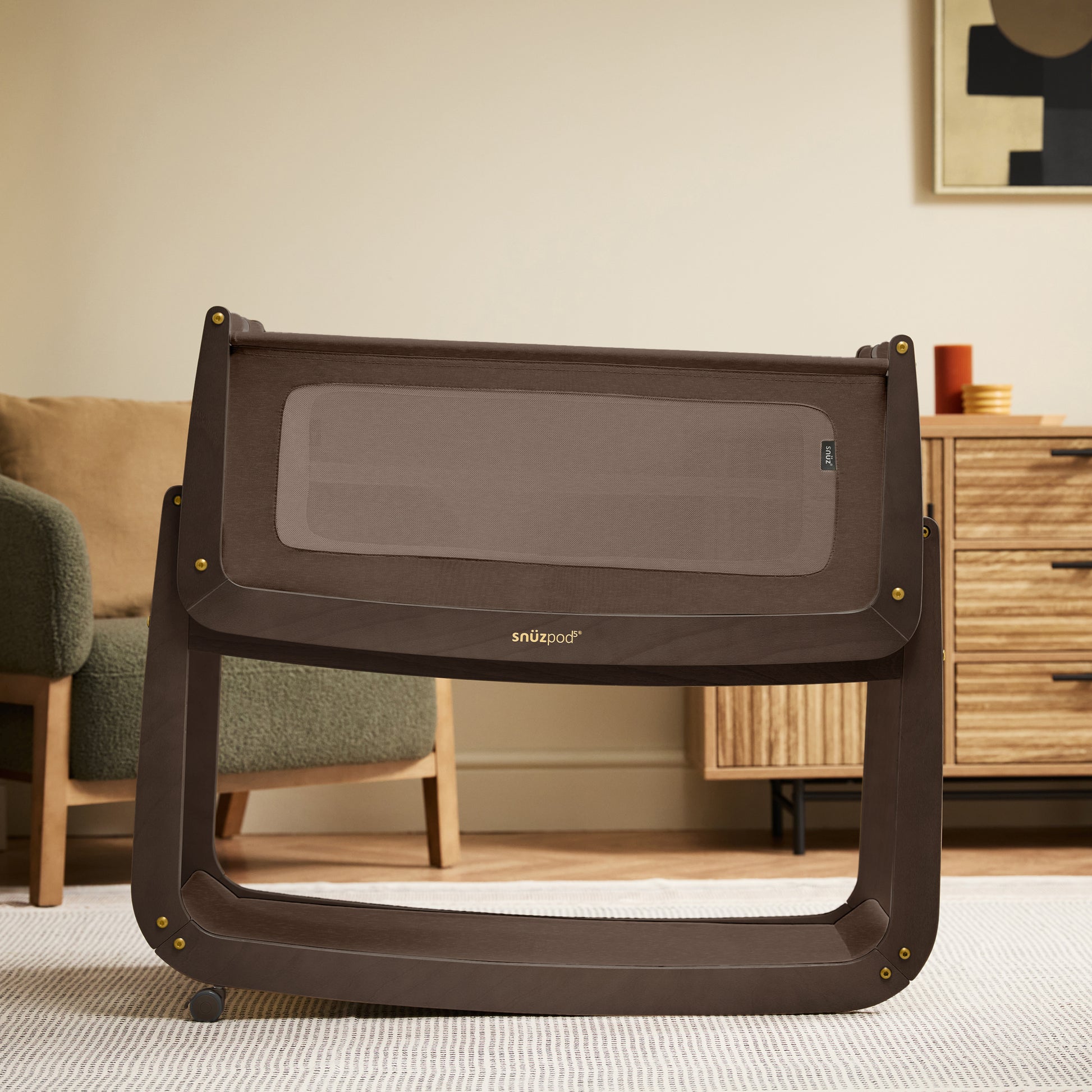 A choclate brown Snuzpod5 bedside crib designed for infants, showcasing a modern and safe sleeping environment.