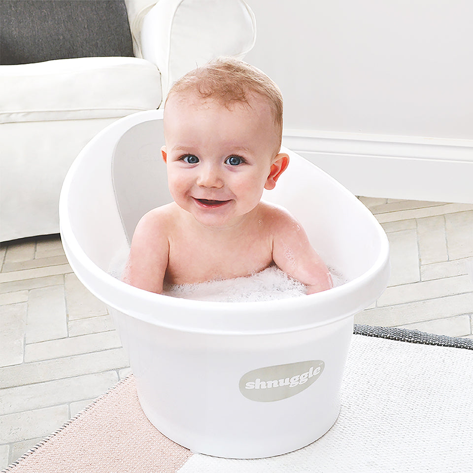 Baby smiling in Shnuggle bath in the white/grey 