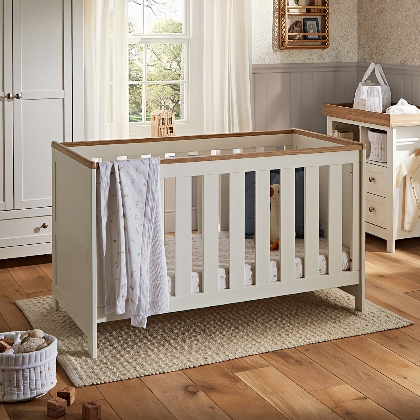 CuddleCo Burford cot bed in white with oak trim.