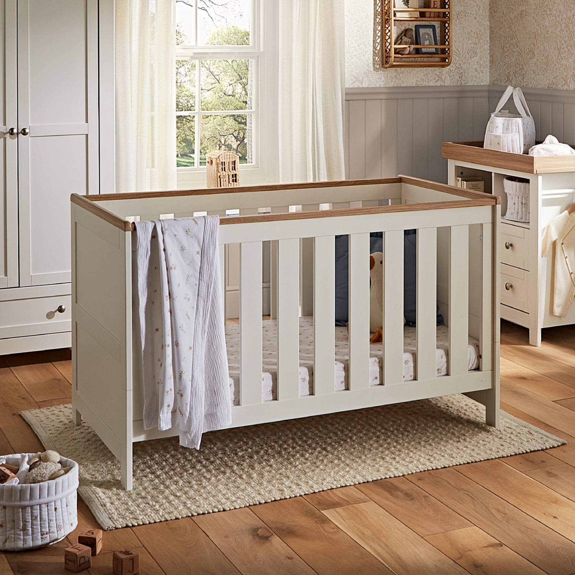 CuddleCo Burford cot bed in white with oak trim.
