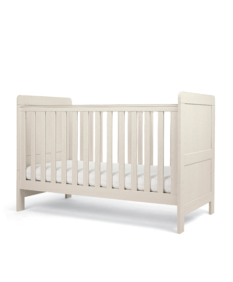 Cot bed with adjustable heights in stone colour.