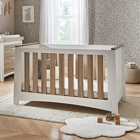 Ada cot bed in white and ash within a nursery