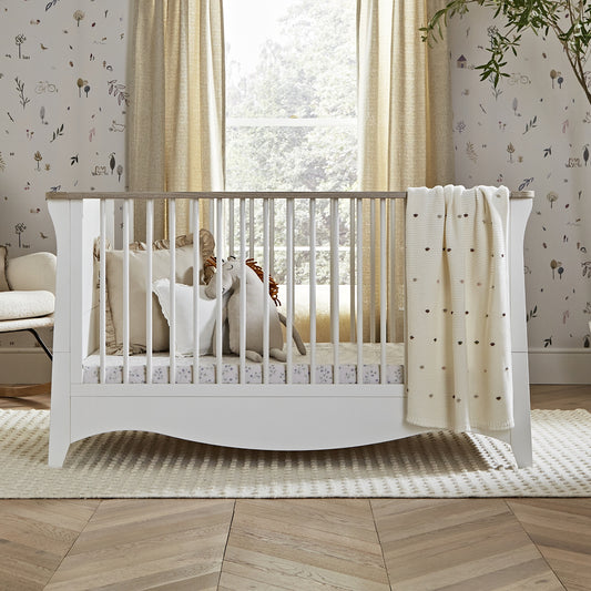 Clara cot bed featuring a white and ash design and includes a mattress.