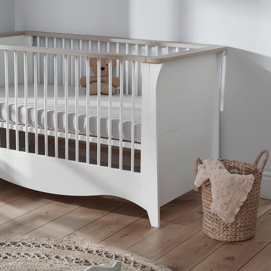 Clara cot bed featuring a white and ash design and includes a mattress.