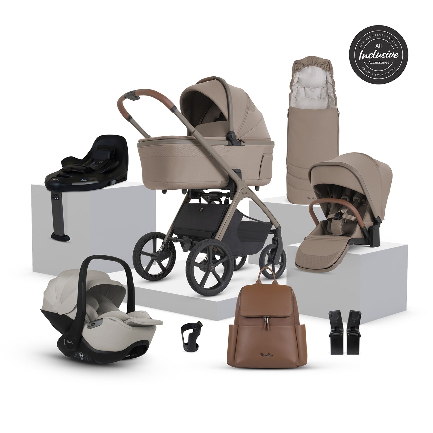 A multi-item silver cross cove 2 travel system set displayed on white pedestals against a white background. The set includes a beige and black stroller, a matching bassinet, a seat, a car seat, a footmuff, a travel bag, a baby backpack, and accessories.