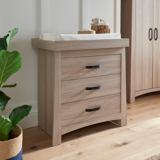 The Isla dresser, featuring an ash finish and stylish black handles, is a piece of furniture that combines modern and traditional styles.