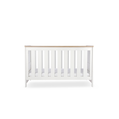 CuddleCo Burford cot bed in white with oak trim. Mattress not included.