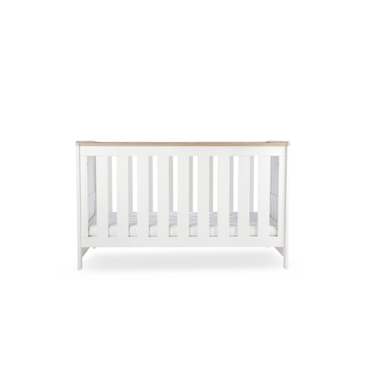 CuddleCo Burford cot bed in white with oak trim. Mattress not included.