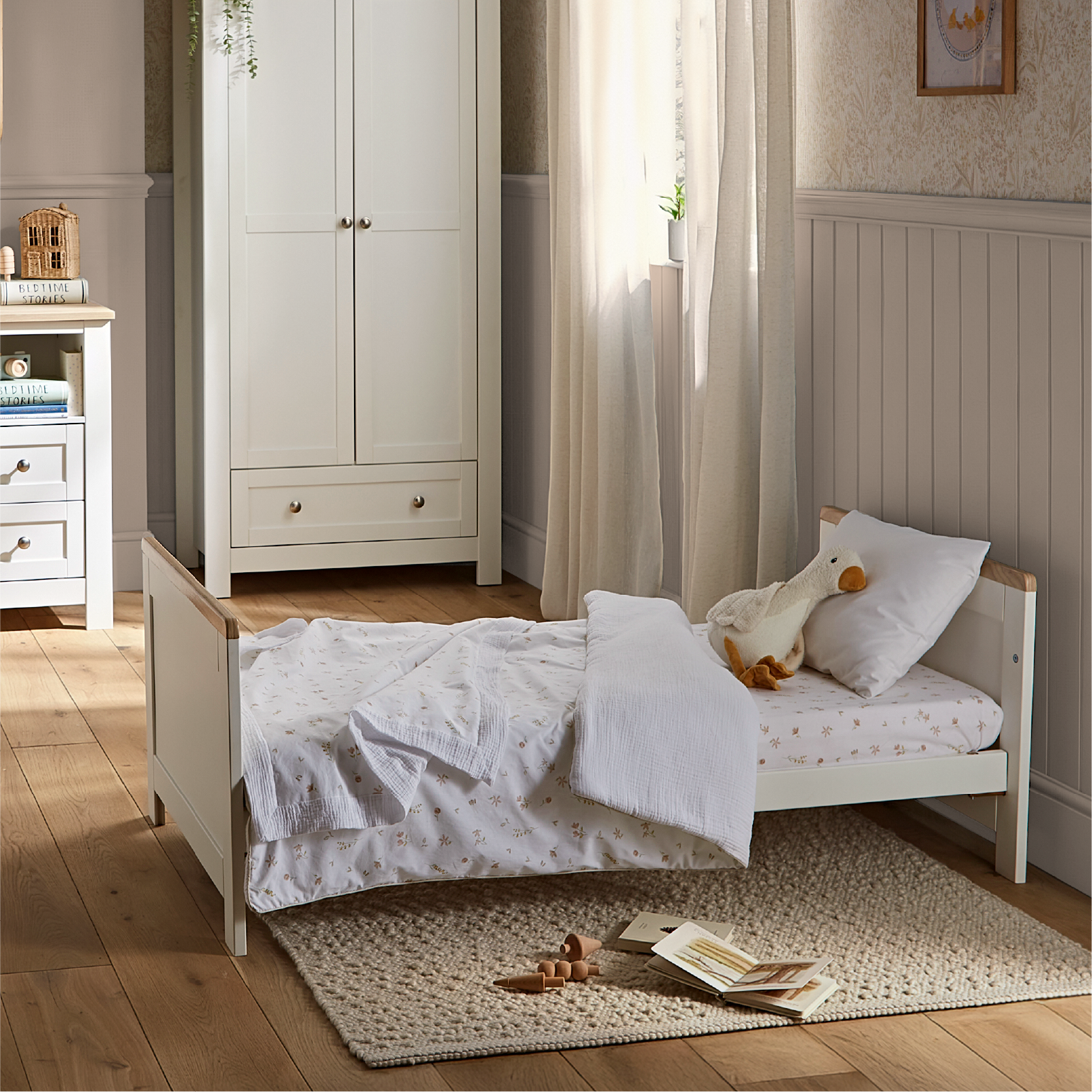 CuddleCo Burford cot bed in white with oak trim.