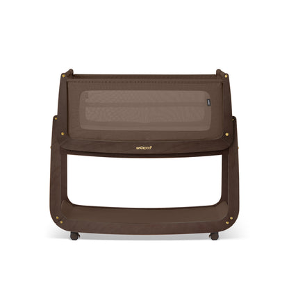 A choclate brown Snuzpod5 bedside crib designed for infants, showcasing a modern and safe sleeping environment.