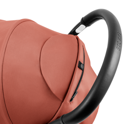 A compact yoyo 5 stroller with a rust-orange canopy and seat lining, a black frame, and black wheels, shown on a plain white background.