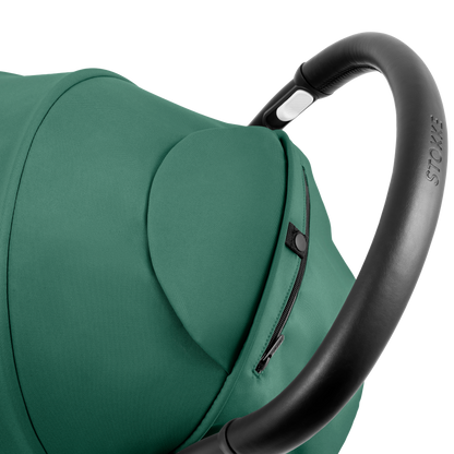 A compact yoyo 5 stroller with a green canopy and seat lining, a black frame, and black wheels, shown on a plain white background.