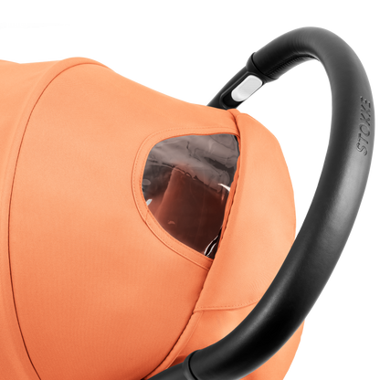 A compact yoyo 5 stroller with a peach orange canopy and seat lining, a black frame, and black wheels, shown on a plain white background.