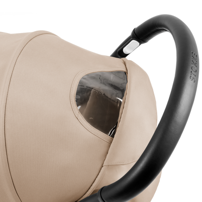 A compact yoyo 5 stroller with a beige canopy and seat lining, a black frame, and black wheels, shown on a plain white background.
