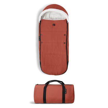 A stroller with a rust-colored padded footmuff, cream fleece lining, and a black frame, shown from the front on a white background.
