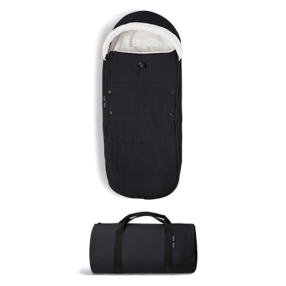 A stroller with a black colored padded footmuff, cream fleece lining, and a black frame, shown from the front on a white background.